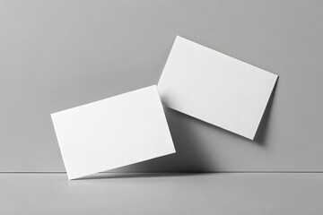 Two blank white business cards on a grey background