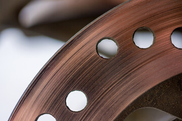 Close-up view of a worn rear disc brake on an automatic scooter.