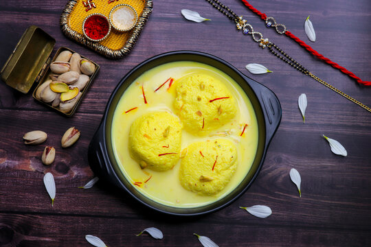 Delicious rasmalai served in a bowl, placed beside a decorative rakhi and a traditional roli chawal thali. A perfect capture of Raksha Bandhan celebrations with sweets, rituals, and festive vibes.