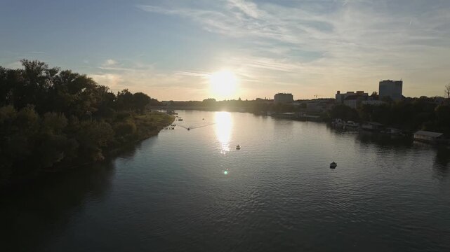 Szeged skyline from the Tisza River in the shadow of the setting sun in Hungary.