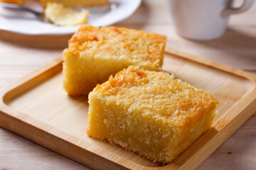 Traditional homemade piece cassava cake whit coconut on a rustic wooden table
