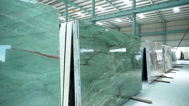Gimbal shot of polished granite and marble slabs in a modern warehouse, highlighting premium textures, vibrant colors, and durability for luxury interiors and architecture.