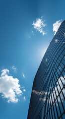 Modern Skyscraper Facade Reflecting Clouds Against a Clear Sky