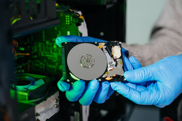Obraz premium Hard disk drive on the technician's desk and a computer motherboard as a component. the concept of data, hardware