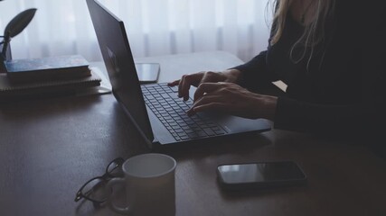 hands typing text close up, dark silhouette body part hand of serious woman looking working on laptop sitting at desk. Joyful energetic adult girl at workplace black room window. manager creating plan - Powered by Adobe