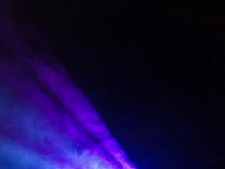 Dark abstract background with vibrant purple and blue smoke effects. Dramatic lighting with ethereal mist creating mystical atmosphere for creative designs