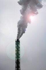 Smoke from chemical plant chimney against blue sky