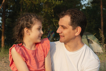 Fototapeta premium Father and daughter smiling together outdoors in evening sun