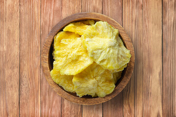 dried fruit, rings pineapple in bowl on wooden table background, top view. organic vegetarian food.