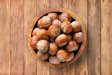shelled hazelnut in bowl on wooden table background, top view. organic vegetarian food.