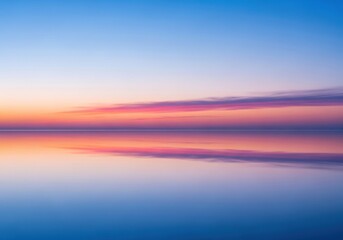 Obraz premium Serene sunset reflection on calm water with soft clouds