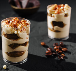 Delicious dessert in clear cups featuring layers of cream and chocolate