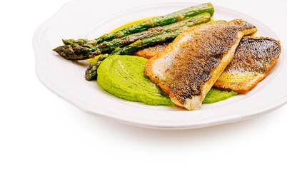 Grilled fish served with vibrant green puree and asparagus on a plate