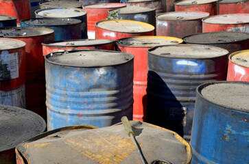 Clustered Barrels of Hazardous Waste. A high-angle view of many old, dirty, and dented oil or chemical barrels in a crowded cluster, suggesting industrial pollution and toxic waste.
