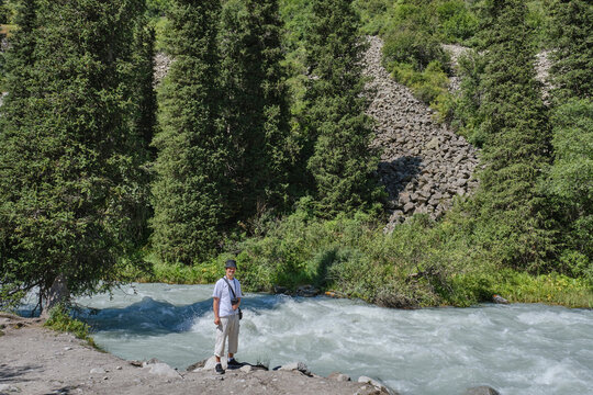 Senior Tourist Standing by Mountain River in Ala-Archa National Park, Kyrgyzstan - Powered by Adobe