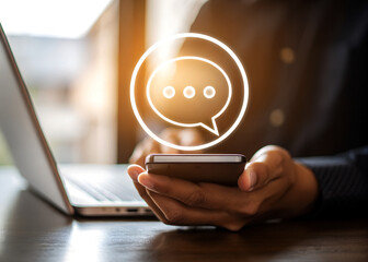 Person using smartphone with glowing chat bubble icon overlay