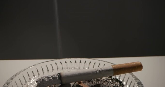 Cigarette Burning In Ash Tray Following Smoke Up