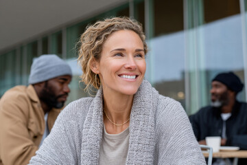 Happy smiling woman enjoying relaxing day with friends at outdoor cafe