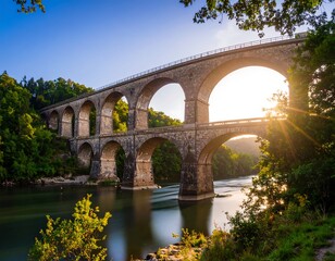 Fototapeta premium A stone arch bridge over a river at sunrise