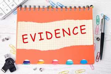 Evidence a word on a sheet from a notebook lying on a notebook next to office supplies, a...