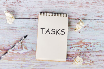 The text of the assignment is written in a notebook lying next to crumpled paper and a pencil