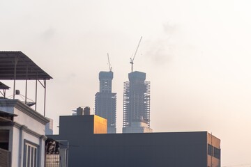 View of buildings under construction with a crane on top. Skyscraper construction.