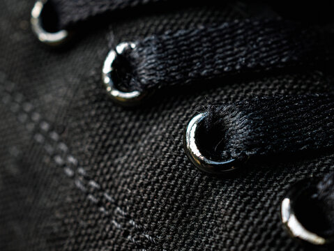 Close-up of lacing of textile sneakers background. side view. Elastic black shoes of mesh fabric trainers, macro