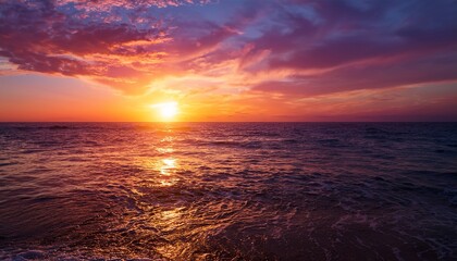 Obraz premium a stunning sunset over the ocean with golden and pink hues reflecting on the water creating a peaceful and picturesque seascape