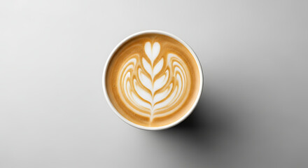 Overhead view of a disposable coffee cup filled with latte art.
