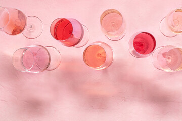 Rose wine assortment, overhead flat lay shot, a variety of hues and tints, on a pink background, many wine glasses, with a place for text