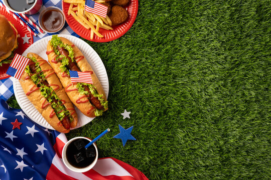 Festive picnic setting with hotdogs, burgers, fries, and desserts for an American celebration like Labor Day or Independence Day, emphasizing patriotism and gatherings