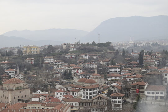 View of rooftops and buildings nestled together, with a mountain range in the distance under a cloudy sky, Safranbolu, Karab&Atilde;&frac14;k, T&Atilde;&frac14;rkiye.