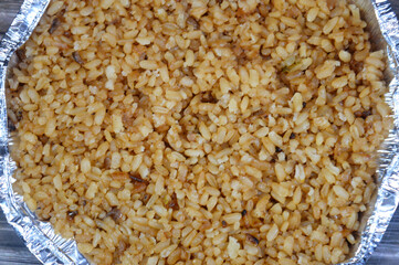 Cooked white Egyptian rice by hot steam and gained the brown color from onions, cooked with seafood cuisines, fish and shrimps, Middle Eastern food concept, Egyptian cuisine background