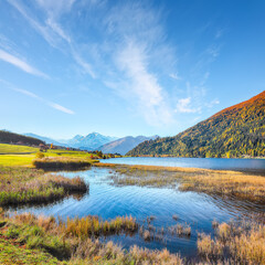 Fabulous autumn view of Haidersee (Lago della Muta) lake with Ortler peak on background.