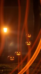 Four jackolanterns ascend from grassy ground illuminated by a lamp Streaks of light streak through the dark