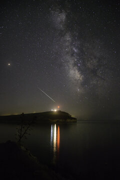 View of the Milky Way arching over the illuminated Porto Palermo bay, its lights reflecting in the calm sea, under a starlit sky, Porto Palermo, Qarku i Vlor&Atilde;&laquo;s, Albania.