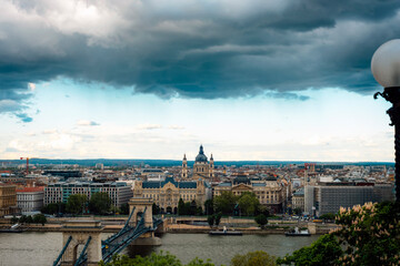 Naklejka premium Historic city skyline of Budapest with Chain Bridge over the Danube River under dramatic cloudy sky