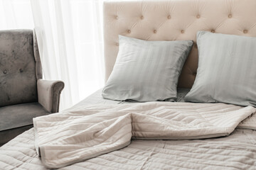 Modern bedroom interior with neatly arranged pillows and cozy bedding