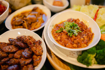 Traditional Japanese style cuisine with rich culture influences features savory dishes served in white bowls with fresh herbs and vegetables creating warm inviting atmosphere