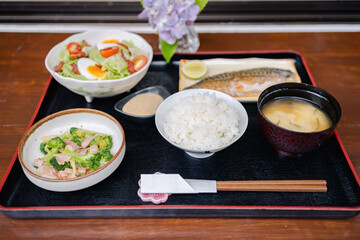 Traditional Japanese style meal with rice grilled fish miso soup and fresh salad reflects culture and offers healthy balanced dining experience full of natural flavors