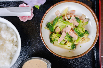 Stir fried broccoli with sliced meat served with white rice and dipping sauce on tray reflects traditional Japanese style and culture in simple and elegant presentation