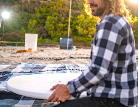 Man on beach, preparing a board
