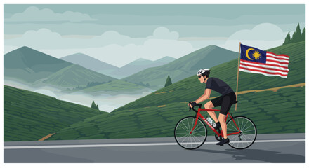 Fototapeta premium A cyclist rides along a scenic mountain road with the Malaysian flag displayed on the roadside.