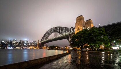 Obraz premium A dramatic city bridge at night, framed by a wet walkway