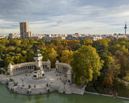 Aerial view of Parque el Retiro with Monumento a Alfonso XII surrounded by lush greenery and tranquil water, Retiro, Madrid, Spain.