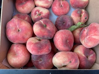 Ripe peaches in a cardboard box.