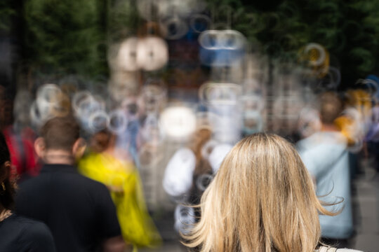Blurry, defocused, unrecognizable people or pedestrians on a busy urban sidewalk.