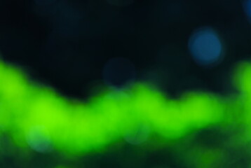 黒い背景に浮かぶ緑の光の背景素材