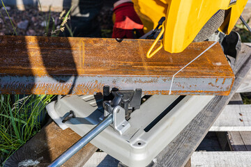 High-powered saw cutting through a rusted steel beam, displaying precise industrial cutting techniques and tools.