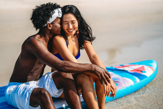 Interracial couple enjoying a romantic beach getaway, embracing love, laughter, and togetherness